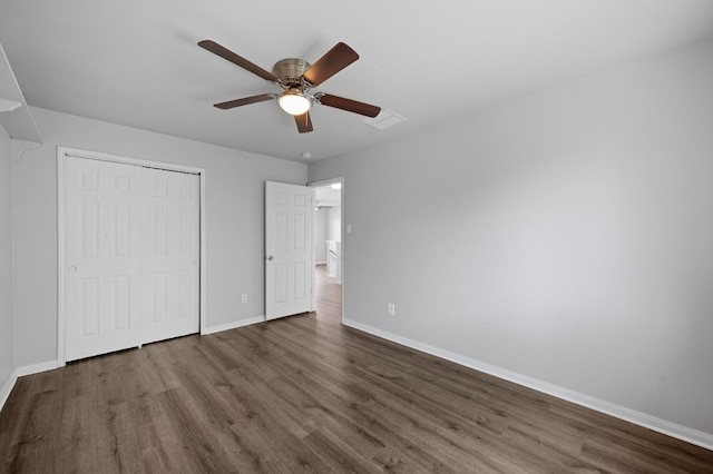 unfurnished bedroom with a closet, dark wood-type flooring, and ceiling fan