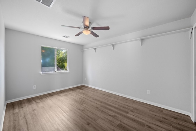 unfurnished room featuring dark wood-type flooring and ceiling fan