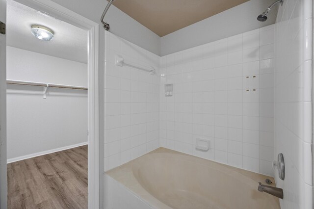 bathroom featuring hardwood / wood-style floors and tiled shower / bath