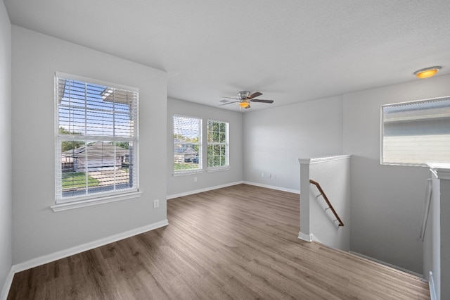 unfurnished room featuring a textured ceiling, hardwood / wood-style flooring, and ceiling fan