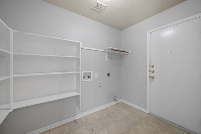 laundry area with hookup for a gas dryer, electric dryer hookup, washer hookup, tile patterned flooring, and a textured ceiling