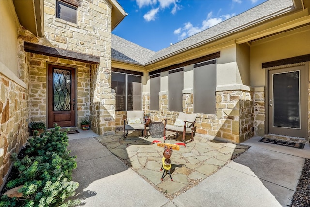 view of exterior entry with a patio