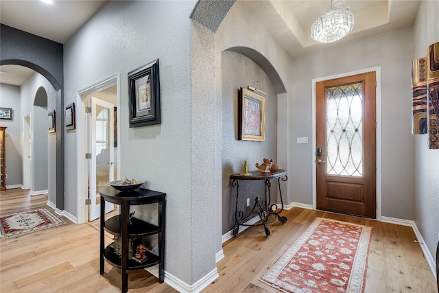 entrance foyer with hardwood / wood-style flooring and an inviting chandelier