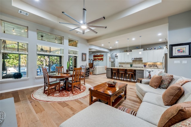 living room with light wood-type flooring and ceiling fan