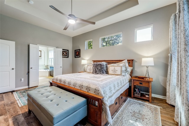 bedroom featuring ensuite bath, wood-type flooring, and ceiling fan