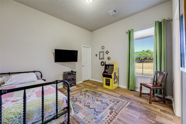 bedroom featuring a textured ceiling and hardwood / wood-style flooring