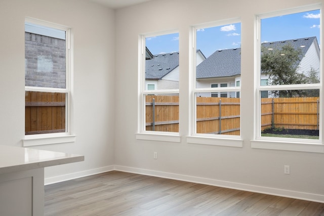 spare room with wood-type flooring and plenty of natural light