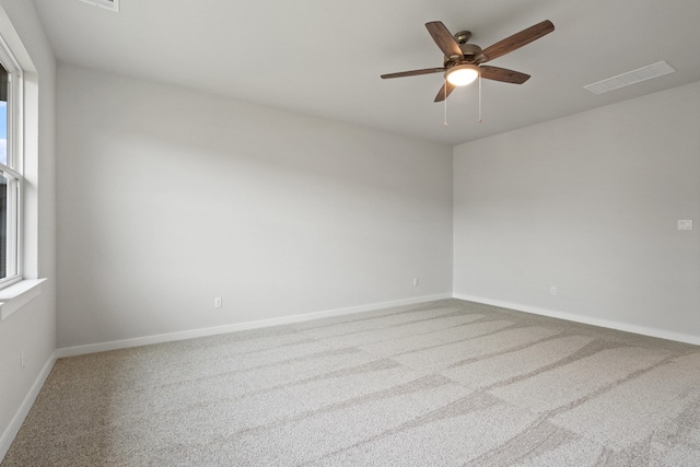 empty room featuring carpet flooring, a healthy amount of sunlight, and ceiling fan