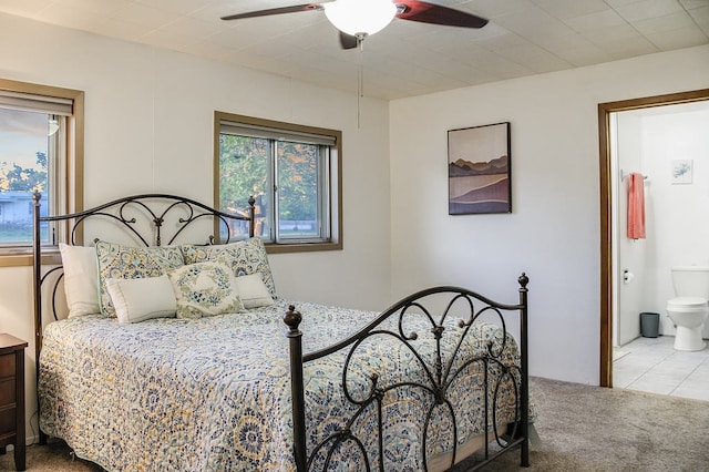 carpeted bedroom with connected bathroom and ceiling fan