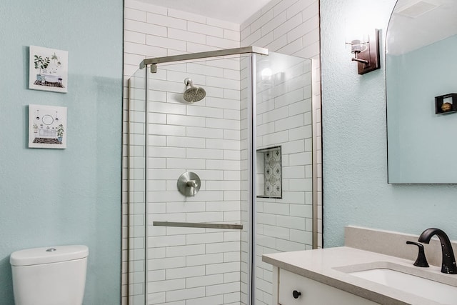 bathroom with vanity, toilet, and an enclosed shower