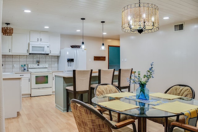 dining space featuring light hardwood / wood-style flooring and a chandelier