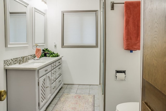 bathroom with vanity, toilet, walk in shower, and tile patterned flooring