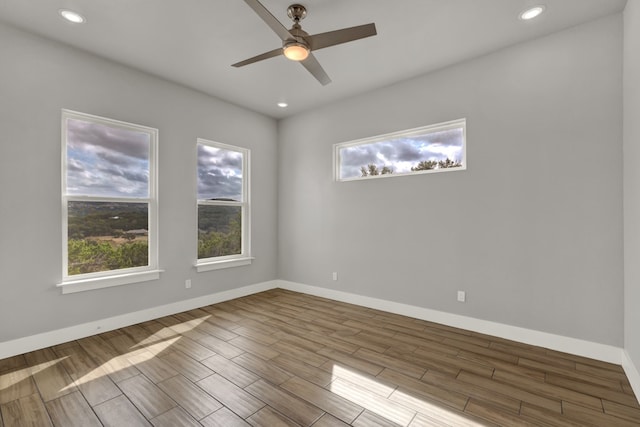 empty room with hardwood / wood-style floors and ceiling fan