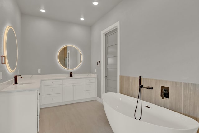 bathroom featuring vanity, hardwood / wood-style floors, and a tub