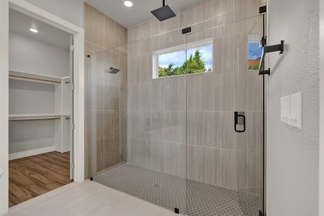 bathroom with a shower with door and hardwood / wood-style flooring