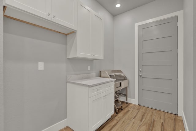 clothes washing area featuring light hardwood / wood-style flooring