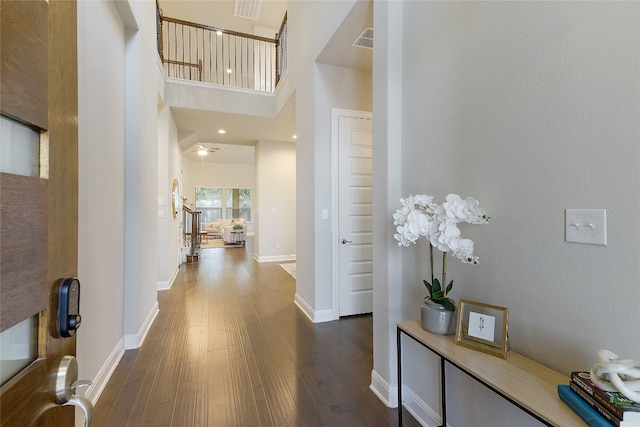 hall with dark hardwood / wood-style floors and a high ceiling