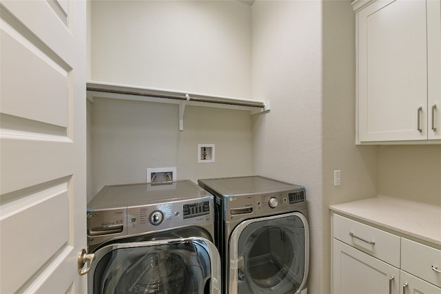 laundry room with washer and dryer and cabinets