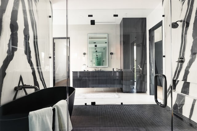 bathroom with a shower with shower door, vanity, and tile patterned flooring