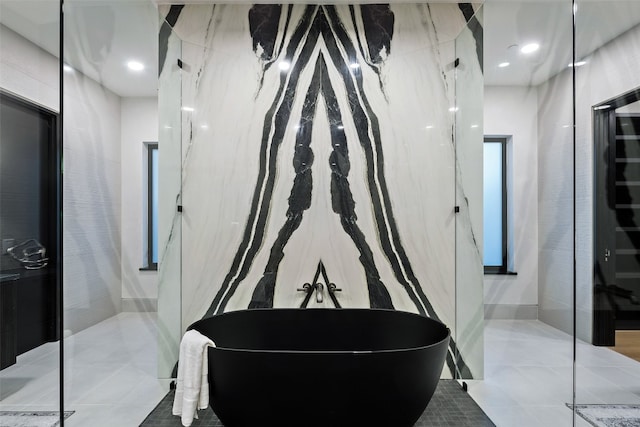 bathroom with tile patterned flooring, tile walls, and a tub