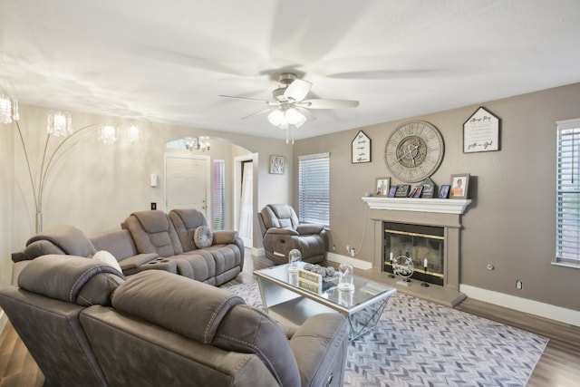 living room featuring wood-type flooring and ceiling fan with notable chandelier