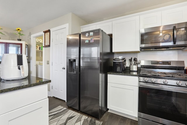 kitchen with dark hardwood / wood-style floors, dark stone countertops, white cabinetry, and stainless steel appliances