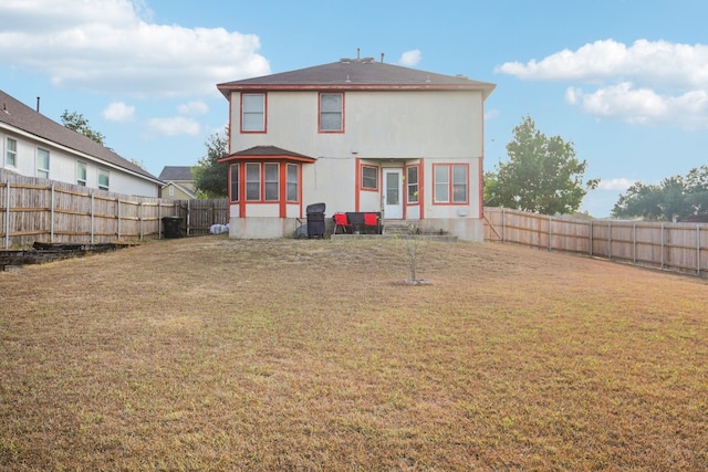 rear view of property featuring a yard