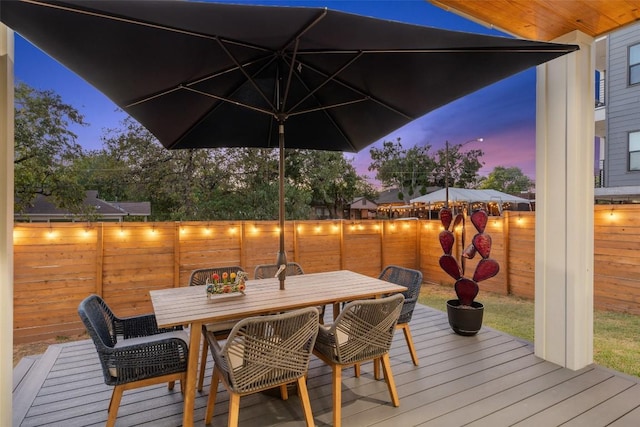 deck at dusk featuring fence private yard and outdoor dining area