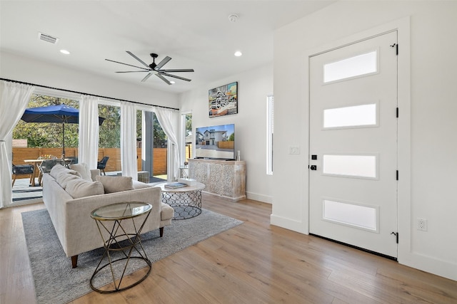 living room with a ceiling fan, visible vents, baseboards, light wood finished floors, and recessed lighting