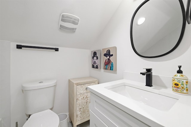 half bath featuring toilet, vanity, and vaulted ceiling