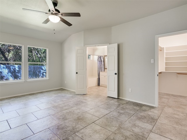 unfurnished bedroom with a walk in closet, a closet, and ceiling fan