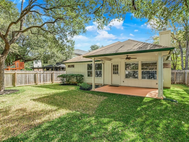 back of property with a yard, a patio, and ceiling fan