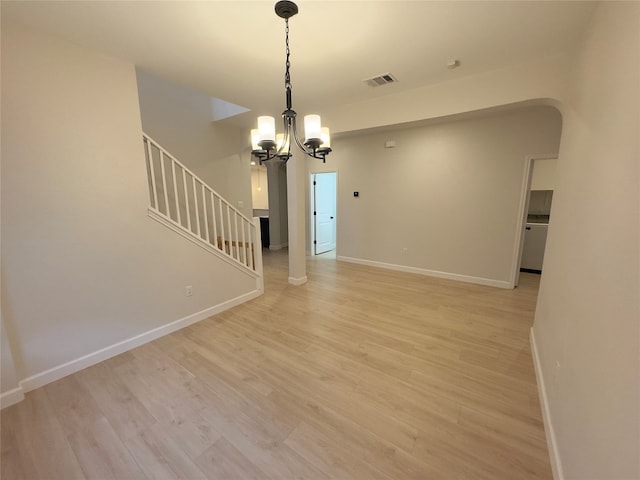 unfurnished living room with light hardwood / wood-style flooring and an inviting chandelier