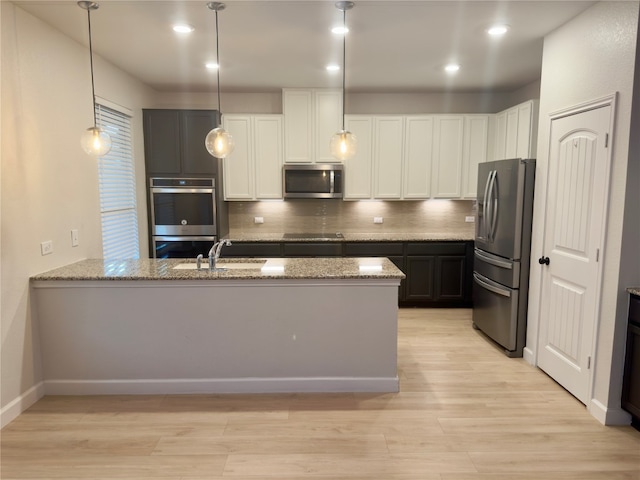 kitchen featuring backsplash, stone countertops, hanging light fixtures, white cabinetry, and stainless steel appliances