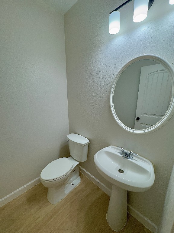 bathroom with hardwood / wood-style flooring and toilet