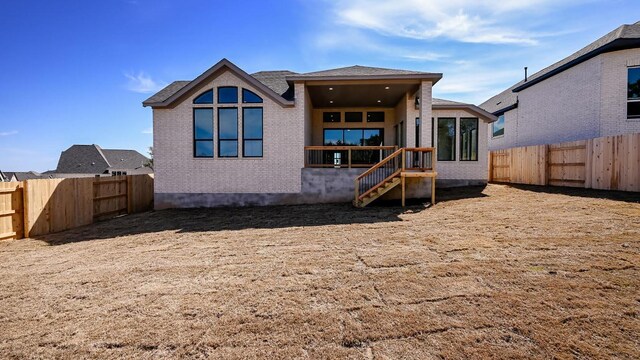 back of property featuring brick siding and a fenced backyard