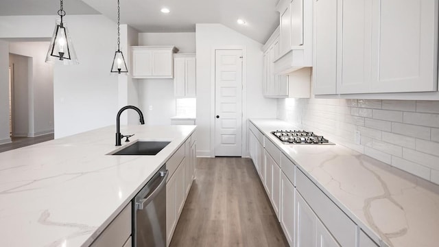920 Teakmill Trl, San Marcos, TX 78666 - kitchen with appliances with stainless steel finishes, a sink, light wood-style floors, white cabinetry, and backsplash