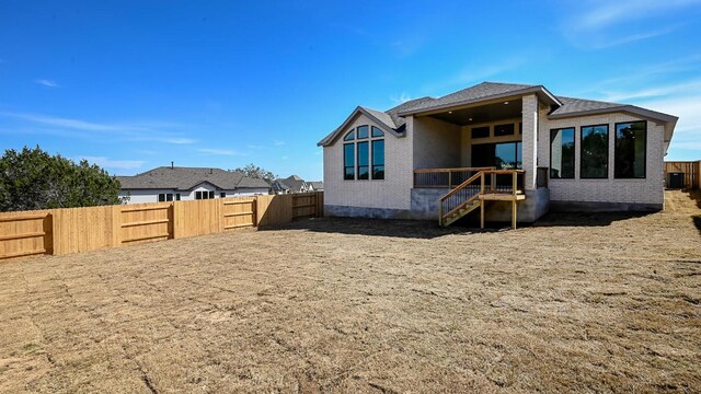 rear view of house with a fenced backyard