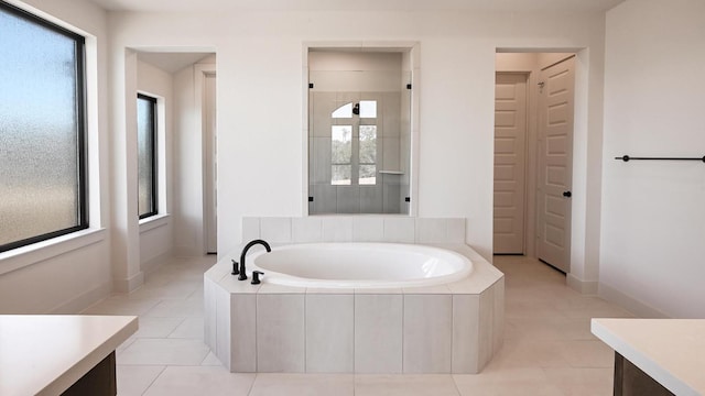 full bath featuring a healthy amount of sunlight, a garden tub, and vanity