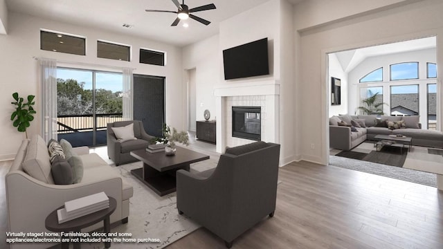 920 Teakmill Trl, San Marcos, TX 78666 - living area featuring a ceiling fan, light wood-type flooring, a fireplace, a high ceiling, and baseboards