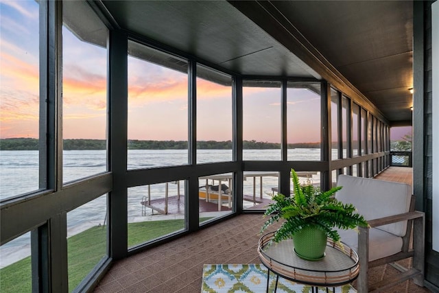 unfurnished sunroom featuring a water view