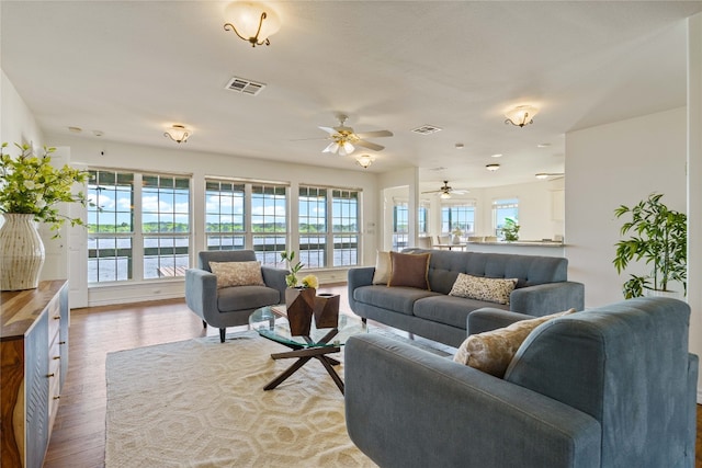 living room featuring ceiling fan and light hardwood / wood-style flooring