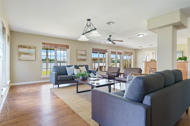 living room with ceiling fan, wood-type flooring, and plenty of natural light