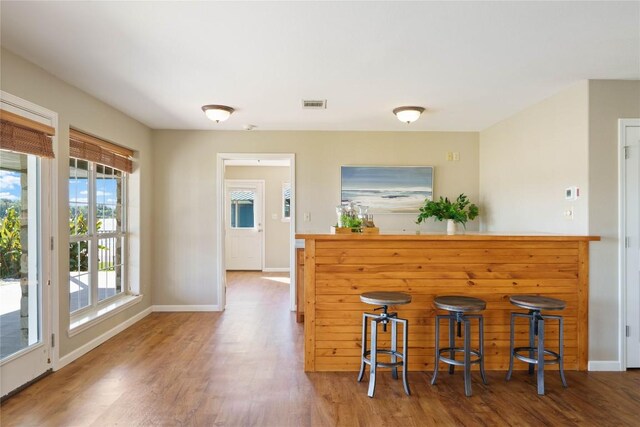 kitchen with a breakfast bar and wood-type flooring