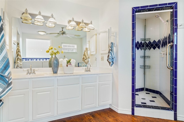 bathroom featuring vanity, ceiling fan, wood-type flooring, and tiled shower