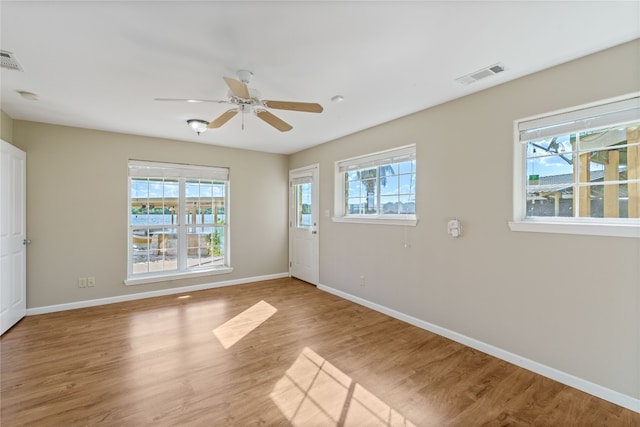 unfurnished room featuring plenty of natural light and hardwood / wood-style floors