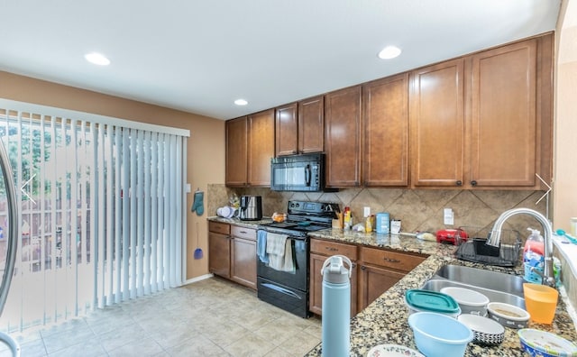 kitchen featuring backsplash, light stone countertops, sink, and black appliances