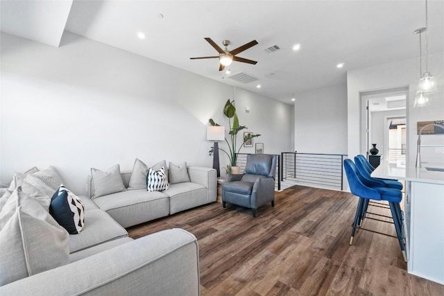 living room featuring ceiling fan and dark hardwood / wood-style flooring