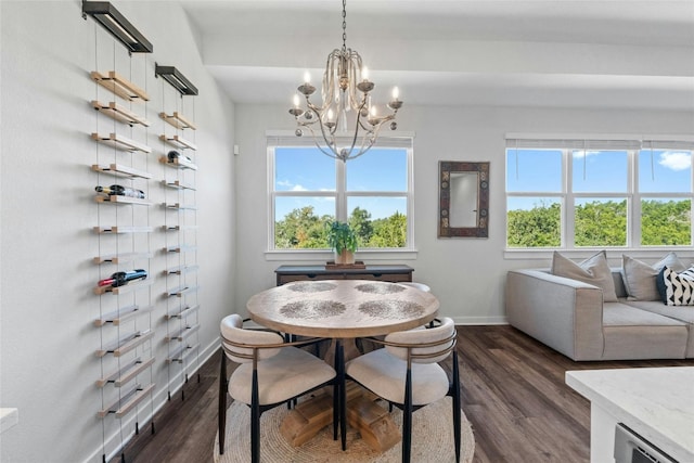 dining space featuring a notable chandelier, a healthy amount of sunlight, and dark wood-type flooring