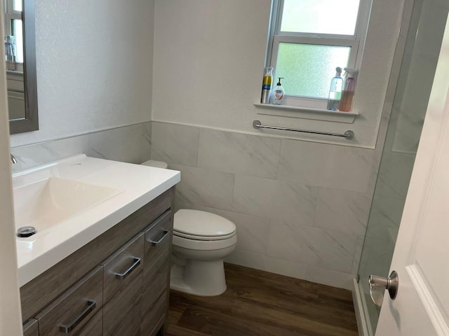 12404 Sceptre Cv, Austin, TX 78727 - bathroom with tile walls, wood finished floors, vanity, and a wainscoted wall